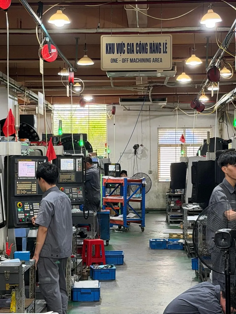 Fertigungshalle für Einzelteilbearbeitung mit CNC-Maschinen und Mitarbeitenden in Vietnam